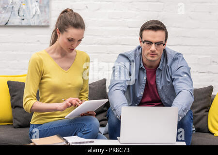 Nach paar Freiberufler auf der Couch zu Hause arbeiten gemeinsam ausgerichtet Stockfoto