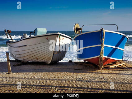 Zwei Boote sitzen auf der Rampe am Meer in der Portugiesischen Fischerdorf Salema, einem kleinen Fischerdorf an der Algarve im Süden Portugals. Stockfoto