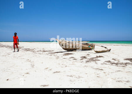 - GALU KINONDO, Kenia - 24. FEBRUAR 2018: Die kenianischen jungen Mann zu Fuß auf den Galu Kinondo - Strand in Kenia, Küste, bei Ebbe. Stockfoto