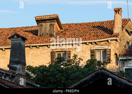 Altes Haus in Venedig mit alten hölzernen Fensterläden und Tondachziegel Stockfoto