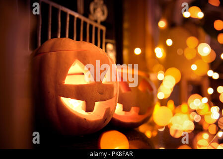 Halloween Kürbisse zu Hause auf einen Kamin mit funkelnden Lichtern. Gemütliche Herbst Hintergrund. Stockfoto