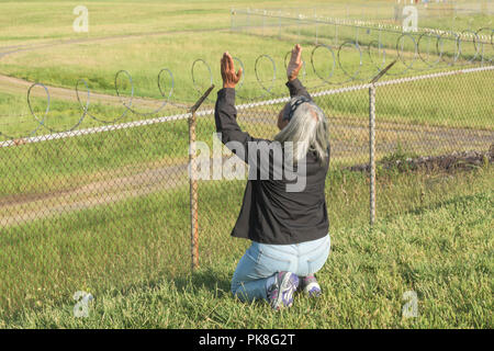 Charlotte, NC - Mai 14, 2017/USA - die Frau, die Gesänge in eine rituelle Gebet, mit Blick auf die Start- und Landebahn am internationalen Flughafen Charlotte-Douglas in Charlotte, NC. Stockfoto