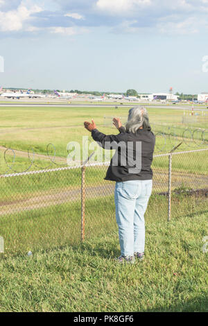 Charlotte, NC - Mai 14, 2017/USA - die Frau, die Gesänge in eine rituelle Gebet, mit Blick auf die Start- und Landebahn am internationalen Flughafen Charlotte-Douglas in Charlotte, NC. Stockfoto