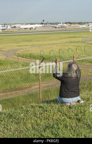 Charlotte, NC - Mai 14, 2017/USA - die Frau, die Gesänge in eine rituelle Gebet, mit Blick auf die Start- und Landebahn am internationalen Flughafen Charlotte-Douglas in Charlotte, NC. Stockfoto