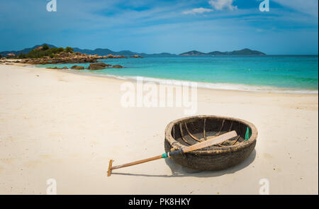 Schönen weißen Sandstrand. Vietnamesische runden Boot auf einen Vordergrund. Schöne Landschaft von Vietnam Stockfoto