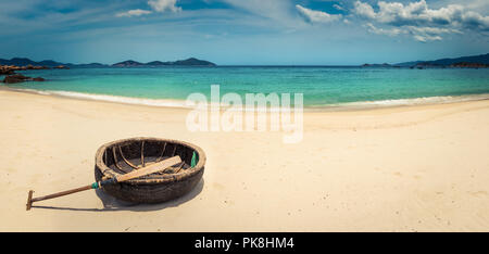 Schönen weißen Sandstrand. Vietnamesische runden Boot auf einen Vordergrund. Schöne Landschaft von Vietnam. Panorama Stockfoto