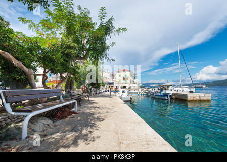 Bank im Schatten unter Bäumen im Hafen von Cres auf der Insel Cres, Kvarner Bucht, Kroatien Stockfoto