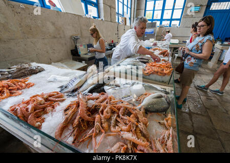 Eine Verkäuferin dient ein Kunde auf dem Fischmarkt in die Halle von Mali Lošinj, Insel Lošinj, Kvarner Bucht, Kroatien Stockfoto