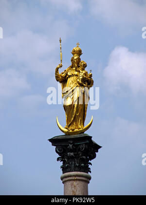 Die goldene Statue der Jungfrau Maria sitzt hoch oben auf dem Mariensaeule in der Marienplatz, in der Landeshauptstadt München, Deutschland, Stockfoto