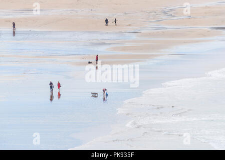 Urlauber zu Fuß auf den Fistral Beach bei Ebbe in Newquay Cornwall. Stockfoto