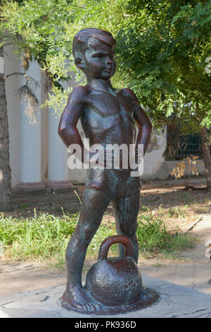 Jewpatoria, Krim, Russland - 30. Juni 2018: Skulptur Boy mit Gewichten auf der Gor'kij-Damm in Jewpatoria, Krim Stockfoto