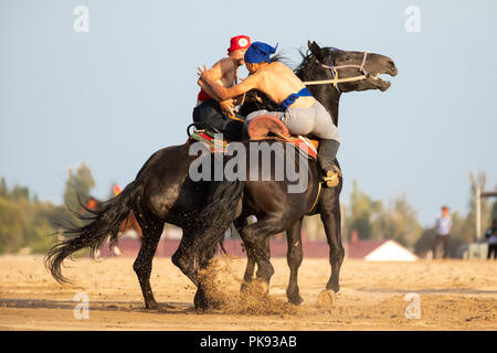 Stadt Cholpon-Ata, Kirgisistan - Sep 5, 2018: Zwei Männer konkurrieren in Er-enish (traditionelle kirgisische Reiter Wringen) Gleiches während 2018 weltweit Nomad Spiele. Stockfoto