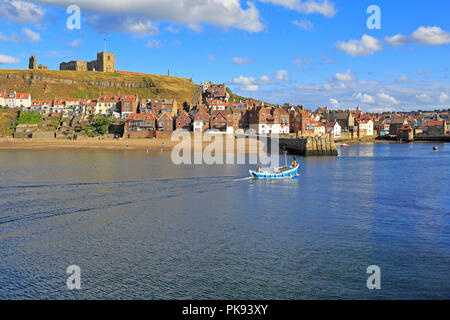 Str. Marys Kirche am East Cliff über Fischerhütten und Tate Hill Pier, niedrigere Hafen von Whitby, North Yorkshire, England, UK. Stockfoto