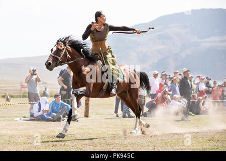 Stadt Cholpon-Ata, Kirgisistan - Sep 6, 2018: Weibliche Bogenschützen auf ein Ziel während einer traditionellen reiten Bogenschießen Wettbewerb zum Ziel haben. Stockfoto