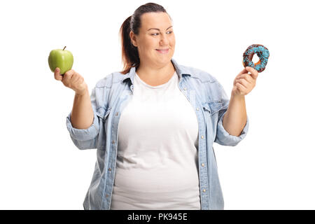 Unentschlossen übergewichtige Frau mit einem Apfel und ein Donut auf weißem Hintergrund Stockfoto