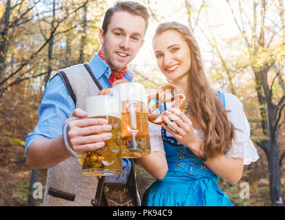 Mann und Frau in bayerischer Tracht Bier trinken. Stockfoto