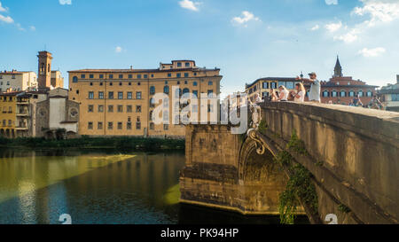 Die Menschen genießen den Blick von der "Ponte Santa Trinita Brücke über den Fluss Arno in Florenz, Toskana, Italien Stockfoto