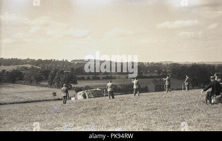 1930er Jahre, historischen, ländlichen Land Verfolgungsjagden, Herren in geeignete Kleidung, die an einem Schießen auf einem Hügel, traditionelle britische Landschaft fieldsport. Stockfoto