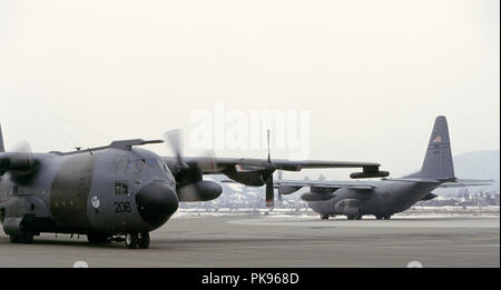 8. März 1993 während der Belagerung von Sarajevo: als Schnee fällt, eine britische Royal Air Force Lockheed C-130 Hercules Verkehrsmittel Flugzeug hat gerade am Flughafen von Sarajevo landete. Im Hintergrund, einer anderen Herkules, der USAF, ist das Rollen vor weg nehmen. Stockfoto