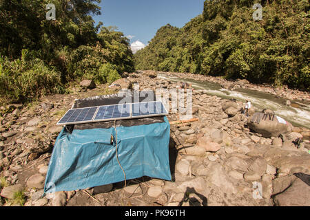 Eine Ladestation mit Sonnenkollektoren an einem Flussufer können die Wissenschaftler auf die Biodiversität Expedition zu entfernten Wald ihre Ausrüstung zu berechnen. Stockfoto