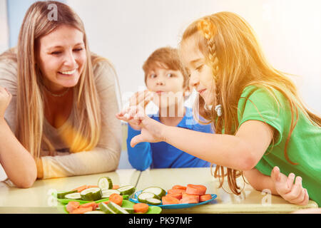 Kinder essen Sie Gemüse zusammen als Snack während der Pausen von der Grundschule Unterricht Stockfoto