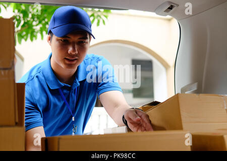Lieferung Mann bei der Arbeit mit Box im Auto, asiatischer Mann arbeiten Job. Stockfoto