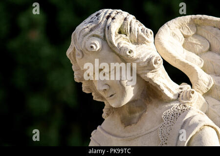 Grabsteine im Friedhof. Schöne Nahaufnahme ein Gesicht Engel Marmorskulptur mit einem süßen Ausdruck, nach unten schaut. Der alte Friedhof mit Grabsteinen. Stockfoto