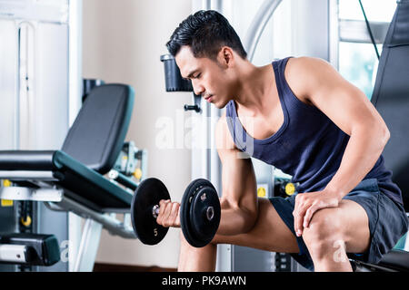 Mann anheben Hantel im Fitnessstudio Stockfoto