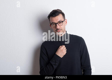 Porträt eines jungen Mannes in einem Studio, das Tragen von schwarzen Rollkragenpullover. Stockfoto