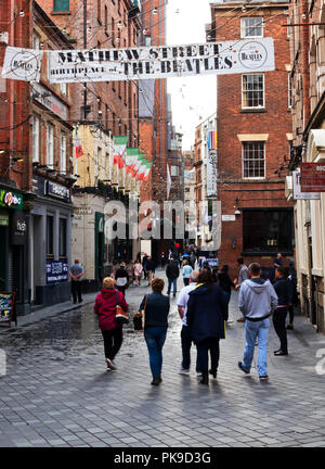 Menschen gehen auf den berühmten Mathew St in Liverpool UK. Der Cavern Club und verschiedene Beatles themed Bars und Clubs. Stockfoto