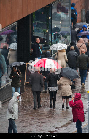 UK Wetter. Menschen unter Regenschirmen in ein heftiger Regenschauer, während Sie einkaufen in Liverpool UK gefangen. Stockfoto