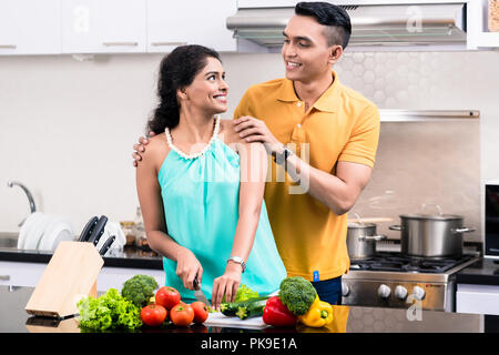 Junge lächelnde Paar in der Küche an jedem anderen Suchen Stockfoto