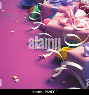 Festliche Hintergrund violett Material bunte Luftballons luftschlangen Konfetti drei Boxen Geschenk. Ansicht von oben flach kopieren Raum toning Stockfoto