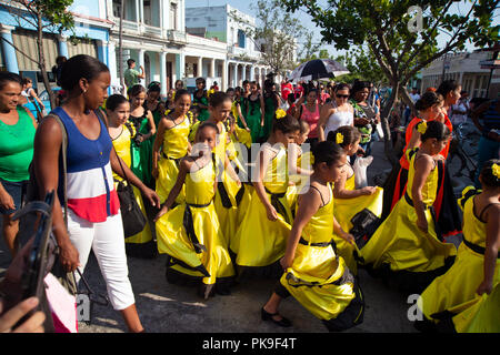 Kubanischen Mutter Hand Ihres Kindes, wie sie in einem bunten Street Parade in Cienfuegos Kuba berücksichtigen Stockfoto