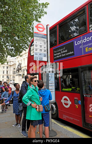 Touristen warten auf einen Bus mit der Horse Guards Parade außerhalb der Whitehall in London England UK KATHY DEWITT Stockfoto