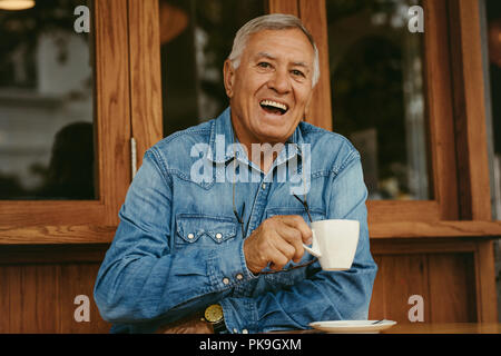 Porträt der freundliche ältere Mann Kaffee im Cafe. Lächelnd alten Mann im Cafe entspannen. Stockfoto
