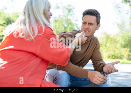 Sorgfältige senior Frau abwischen Mund des jungen Mannes Stockfoto