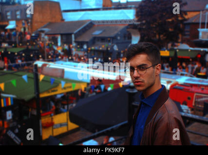Portrait Junge spanische Mann mit runden smart Gläser in eine Straße Messe Konzert Spiel Stockfoto