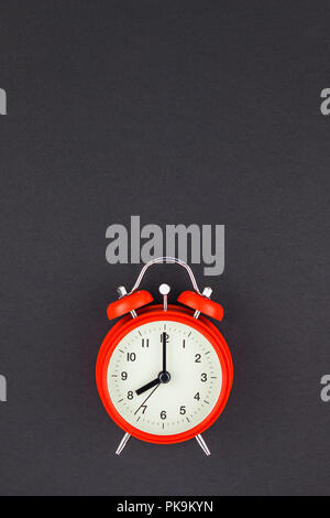 Konzept Bild eines roten vintage Wecker mit acht Uhr auf dunklem Schwarz Papier Hintergrund mit Kopie Raum im minimalistischen Stil, Vorlage für Text Stockfoto