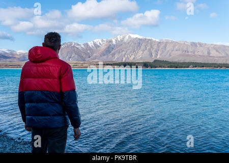 Mann mit Blick auf Berge und Sicht auf den See Tekapo Stockfoto