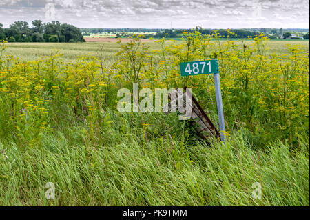 Verfallende Zaunpfosten und Haus Nummer neben New Metal Adresse post und Anzahl Stockfoto