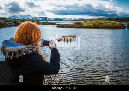 Mädchen schlägt Foto von See Thingvellir in Island im Winter Stockfoto