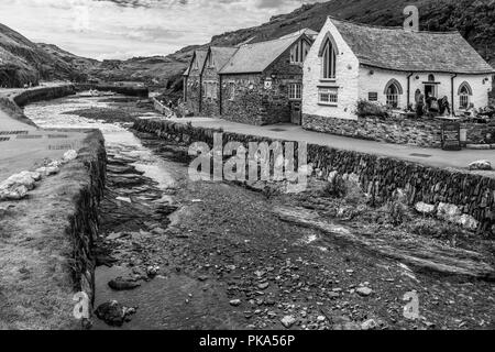 Touristen genießen eine kurze Atempause von der anhaltenden Stürme, die in den malerischen kleinen Hafen von Boscastle an der Nordküste von Cornwall. Stockfoto