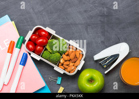 Lunchbox für die Schule, Reis gewickelt in Seetang mit Wurst, Eier- und Apple. Ansicht von oben. Stockfoto