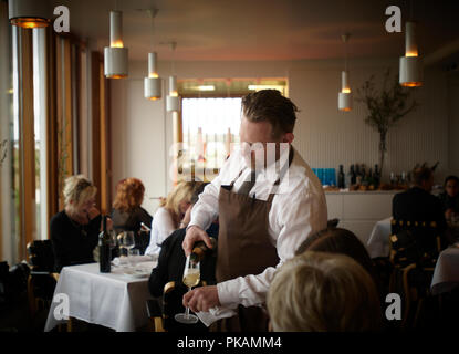 Ólafur Örn ("óli") Ólaffson ist der Sommelier an der Dill Restaurant. Er serviert Wein zu glücklichen Kunden. Stockfoto