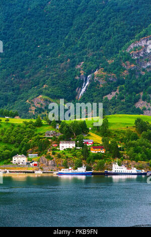 Norwegischen Dorf, Wasserfall und Sognefjord Fjordlandschaft in Flam, Norwegen. Tourismus Urlaub und Reisen Hintergrund Stockfoto