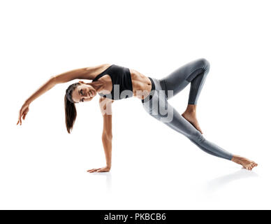 Junges attraktives Mädchen üben Yoga auf weißem Hintergrund. Konzept des gesunden Lebens und der natürlichen Balance zwischen Körper und geistige Entwicklung. F Stockfoto