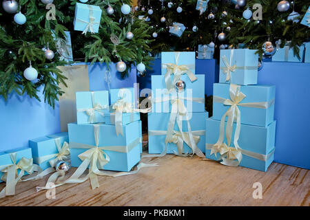 Grünen Tannenbaum. Geschmückten Zimmer mit schönen Tanne. Weihnachten und Neujahr, blau Geschenke. Sammlung von kleinen handgefertigte Geschenk Boxen in einem schneebedeckten Miniatur immergrünen Wald Stockfoto