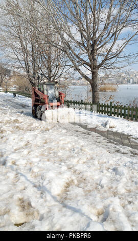 Mini Track entfernt Schnee vom Bürgersteig Stockfoto