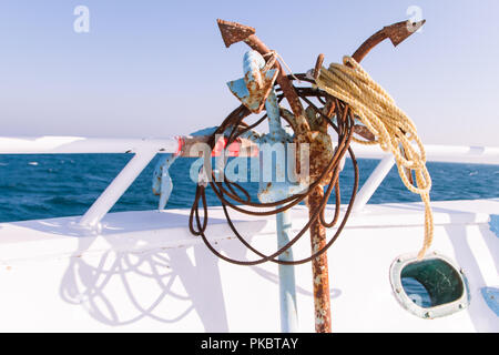 Rostiger Anker auf dem Tauchboot Deck in der Sonne mit Blick auf das Meer im Hintergrund Stockfoto